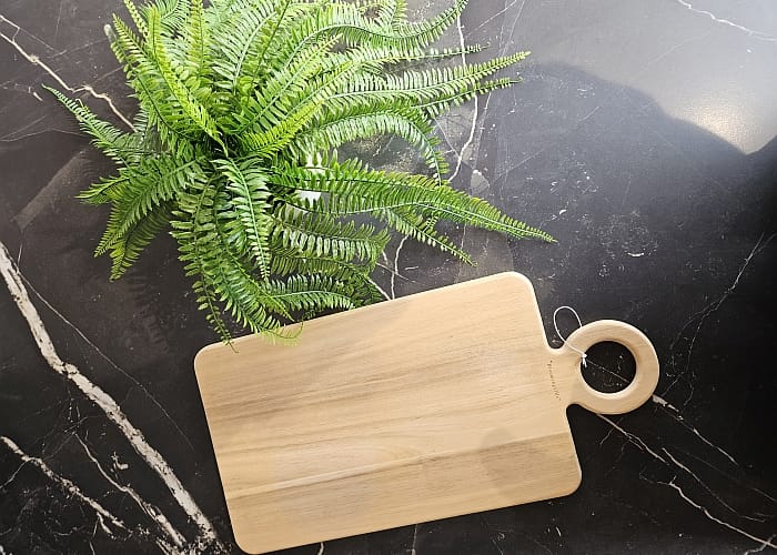 Surface en Dekton noir marbré avec plante et planche à découper